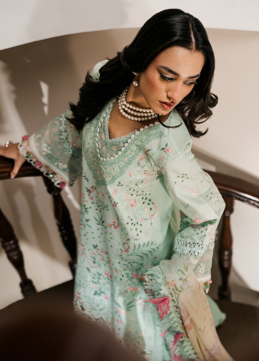 Top view close-up of a woman wearing a pastel mint green embroidered lawn suit, showing intricate embroidery on the neckline and lace-detailed sleeves.