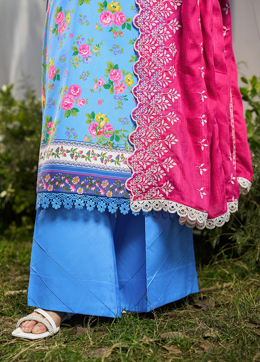 Close-up of solid sky-blue cambric wide-legged trousers paired with floral printed lawn shirt and white sandals on grass
