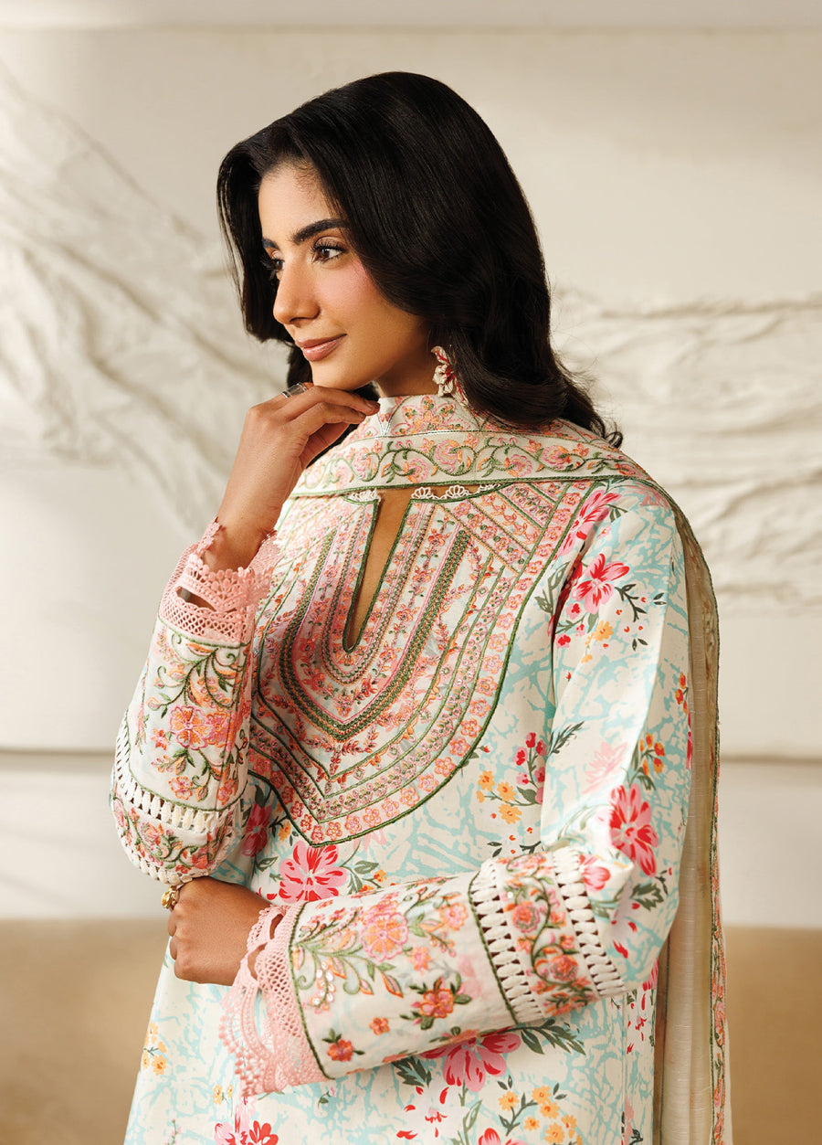 Close-up profile of a woman wearing the embroidered floral lawn suit, focusing on the intricate neckline embroidery, sleeve lace, and soft pastel floral print.