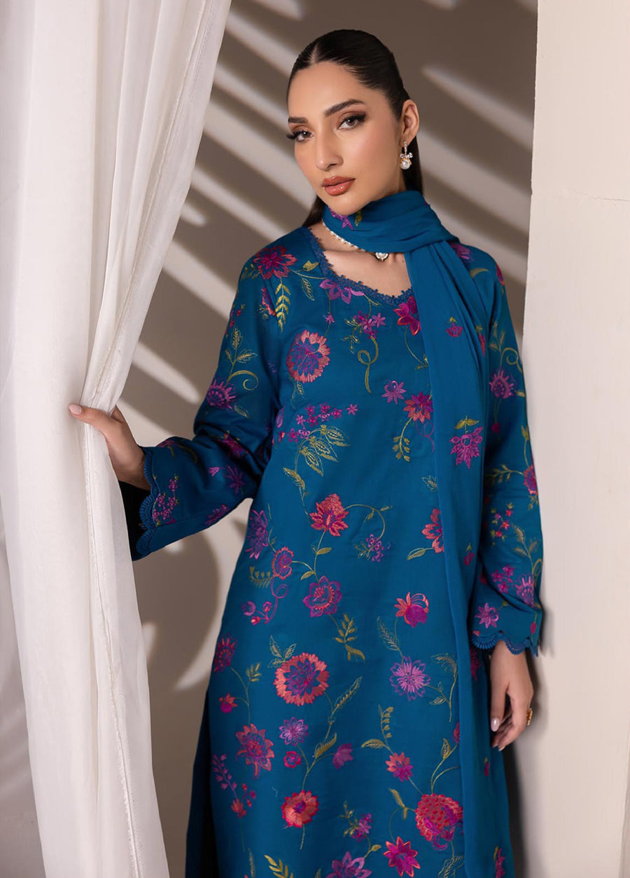 Close-up of the floral embroidery on the thin lawn fabric highlighting the craftsmanship and vibrant colors on the blue fabric