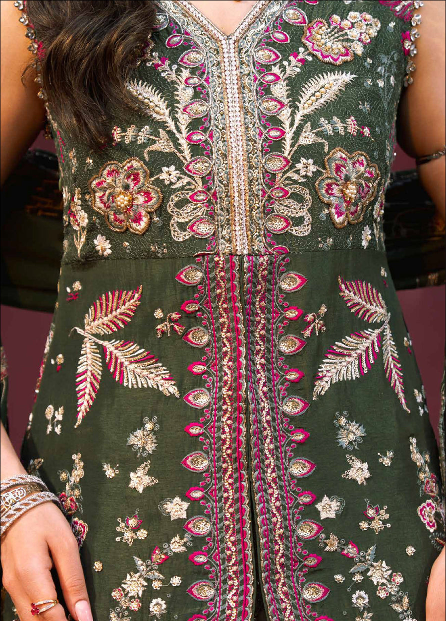 Detailed close-up of the lower part of the dark green tunic and hemline embroidery in pink and gold, alongside the textured golden lehenga with diamond quilting pattern.