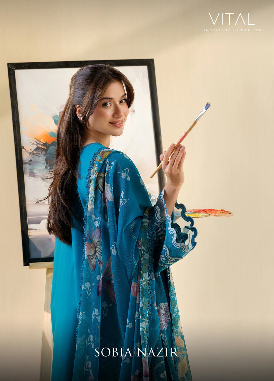 Woman holding a paintbrush and palette, wearing teal embroidered lawn suit with floral printed chiffon dupatta