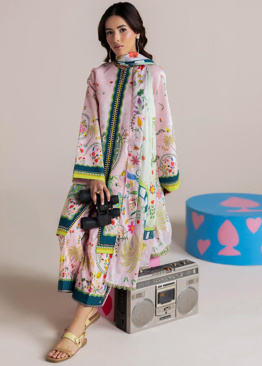 Woman sitting holding binoculars, wearing pastel pink floral printed lawn suit with complementing dupatta and showcasing detailed prints and lace edging