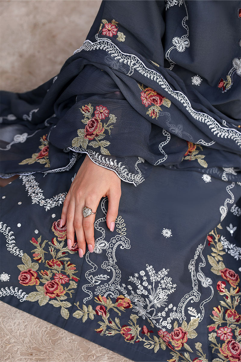 Detailed view of the sleeve cuff and hemline embroidery featuring red and cream floral motifs with scalloped edges on dark fabric