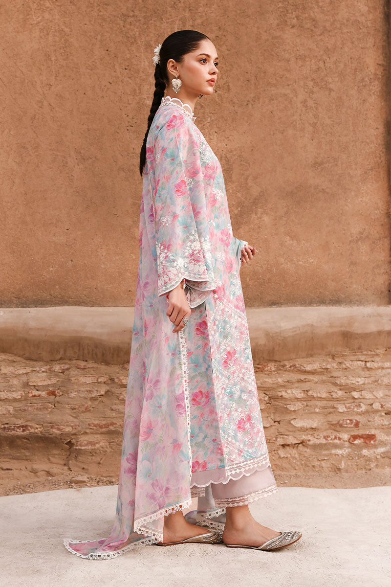 Side view of woman wearing pastel floral embroidered lawn suit with lace-trimmed trousers and matching dupatta