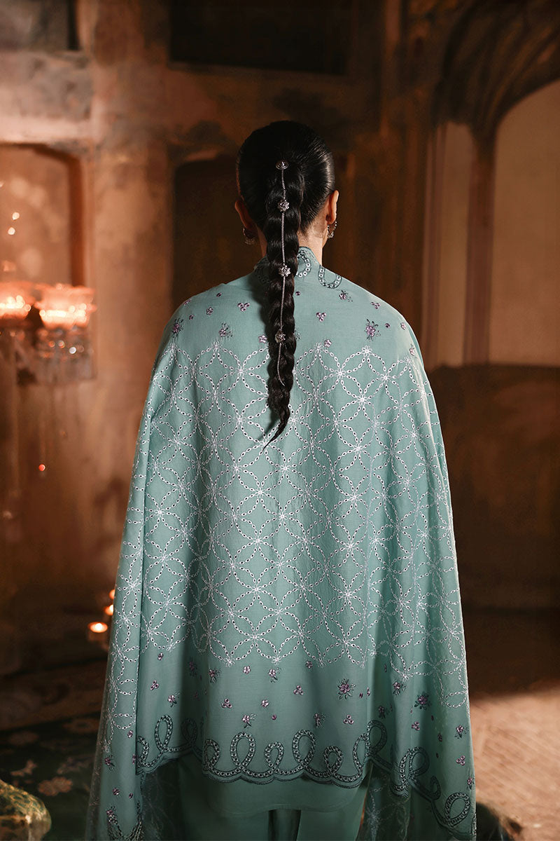 Back view of a woman standing, highlighting the embellished embroidered dupatta and long braided hair with decorative hairpins.