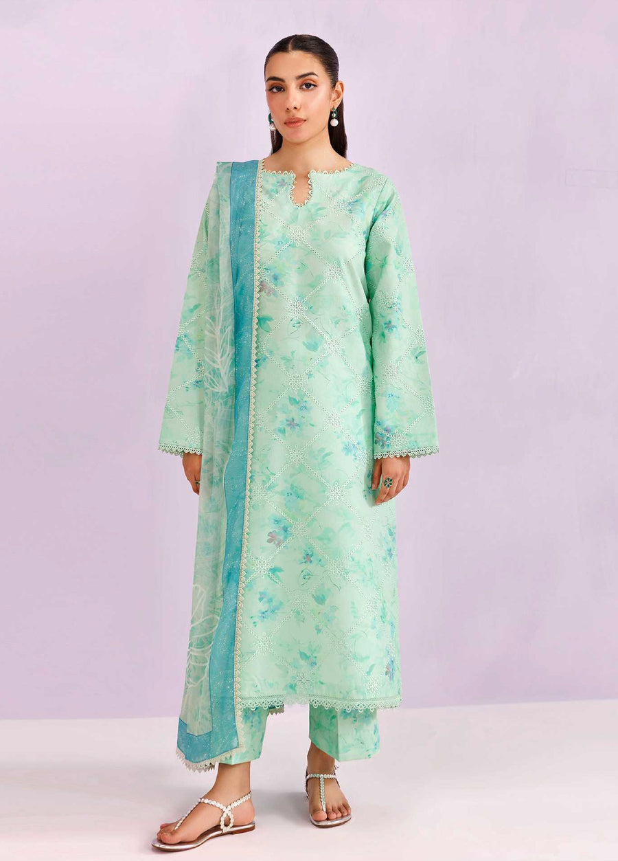 Woman wearing an embroidered mint green 3-piece lawn suit with floral patterns and matching trousers, paired with a chiffon dupatta, standing against a light purple background.