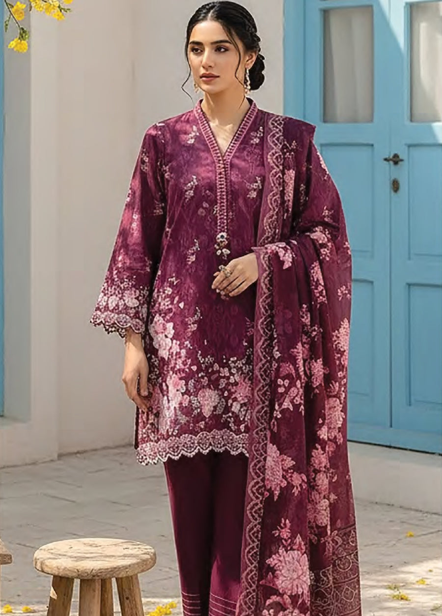 Woman wearing deep plum floral printed lawn suit with scalloped lace edges and matching dupatta standing outdoors near light blue door