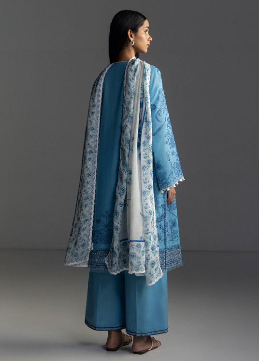 Back view of woman in blue embroidered lawn shirt and trousers, draped with white floral printed dupatta featuring lace edging