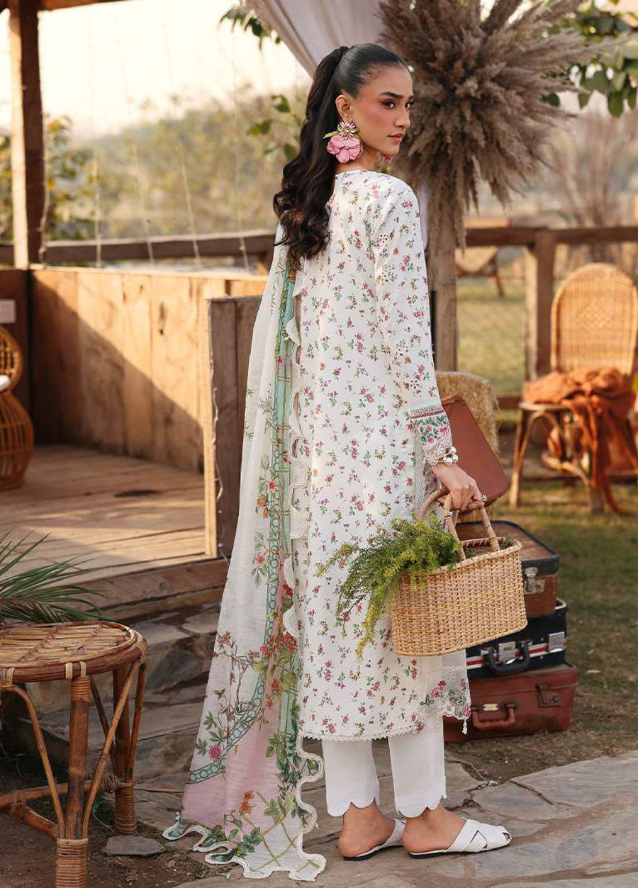Back view of woman in white floral lawn suit showing scalloped hem trouser and pastel floral printed dupatta holding a woven handbag