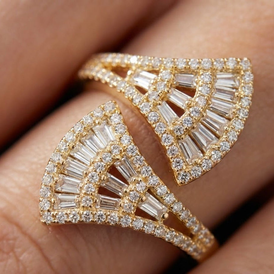 Close-up of the gold fan-shaped ring on a finger highlighting detailed stones and craftsmanship