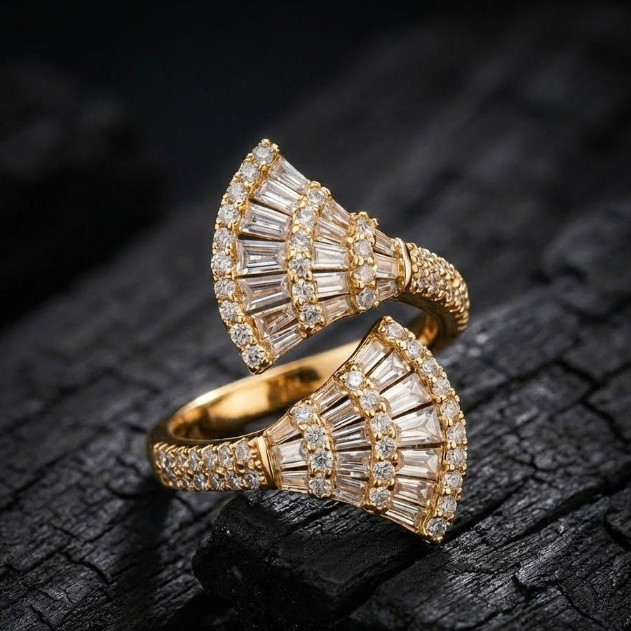 Gold fan-shaped ring displayed on a dark textured background emphasizing brilliance of stones