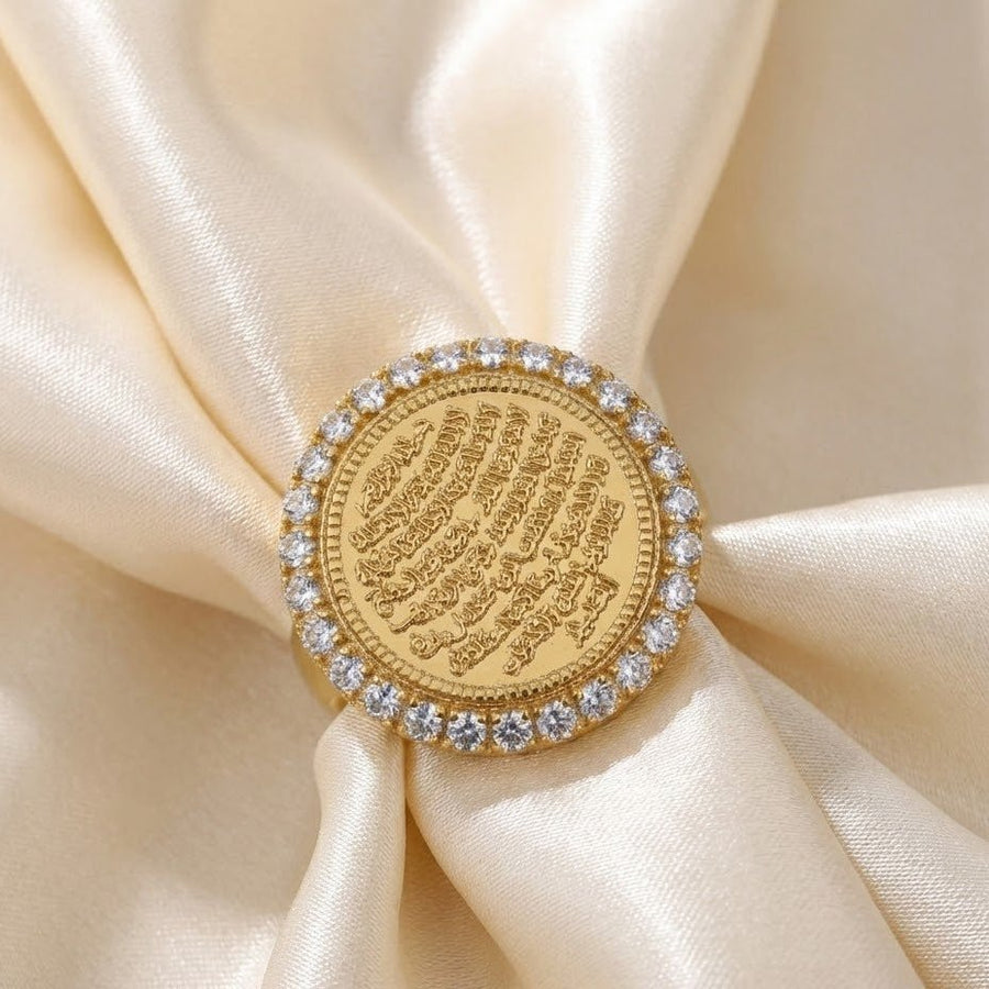 Ayut-Ul-Kursi ring displayed on cream-colored satin highlighting intricate engraving and stone halo