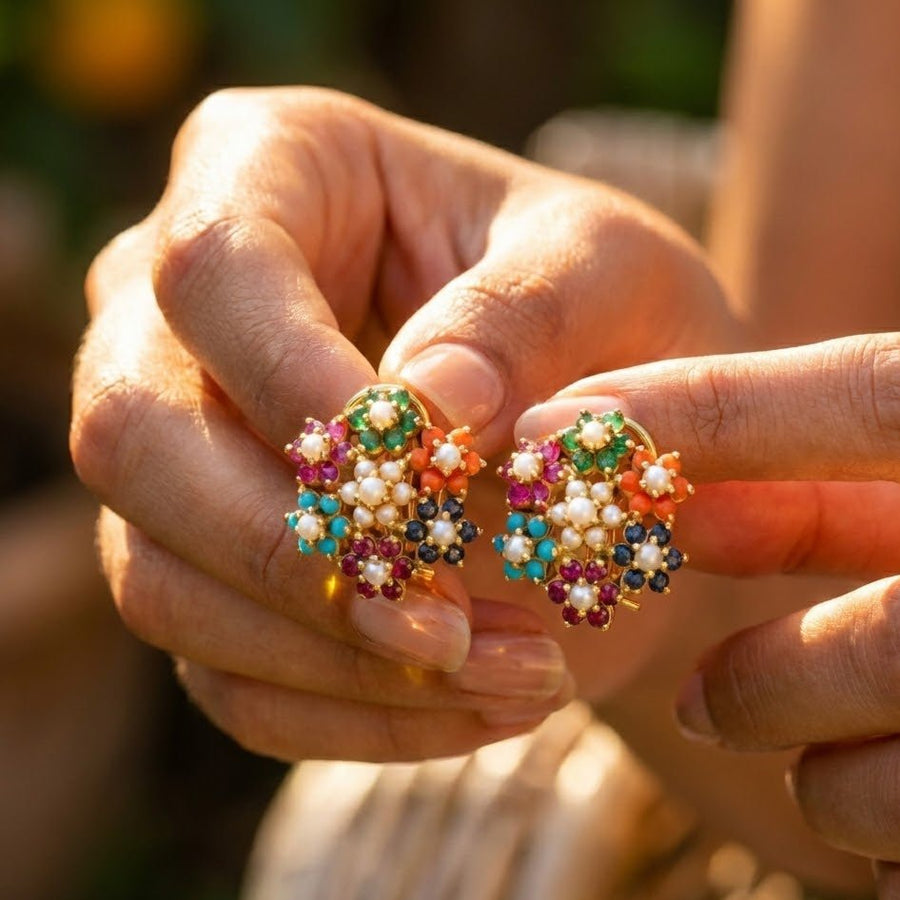 Hands holding the multicolor floral cluster earrings, highlighting size and intricate detail