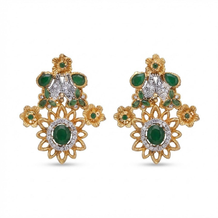 Pair of floral earrings with rich green gemstones and clear accents in gold-tone metal on white background