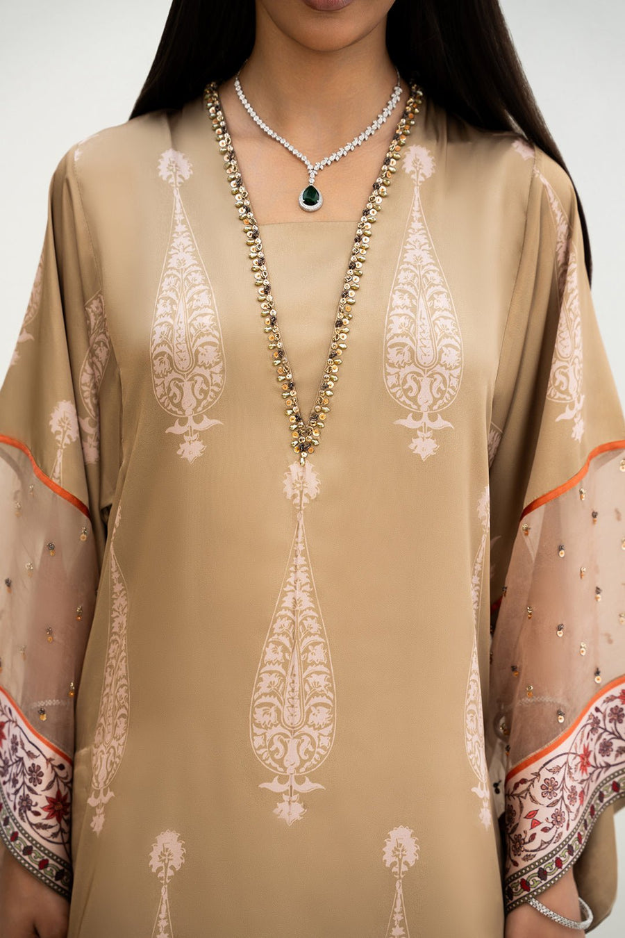 Close-up of embellished V-neckline and printed motif pattern on beige kurta with sheer, sequin-adorned flared sleeves.