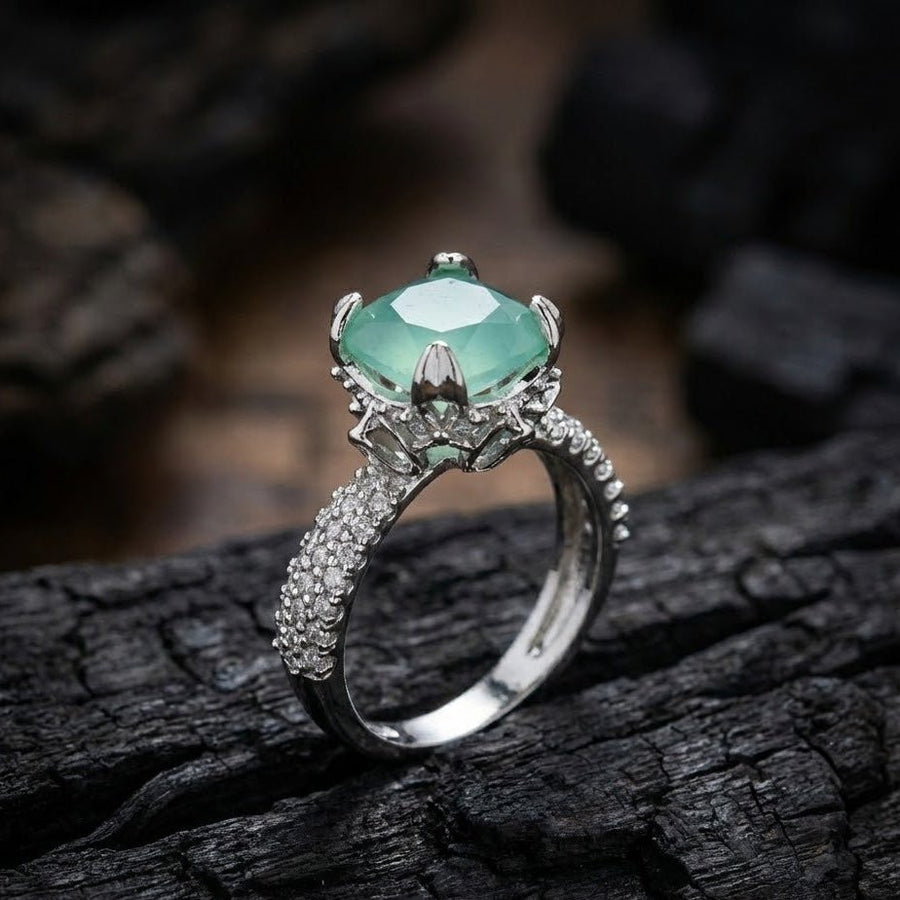 Silver cocktail ring with light green cushion-cut gemstone and pave-set accent stones on band