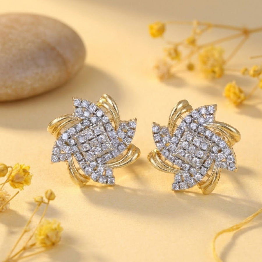 Gold and crystal floral stud earrings surrounded by dried yellow flowers on a soft yellow background