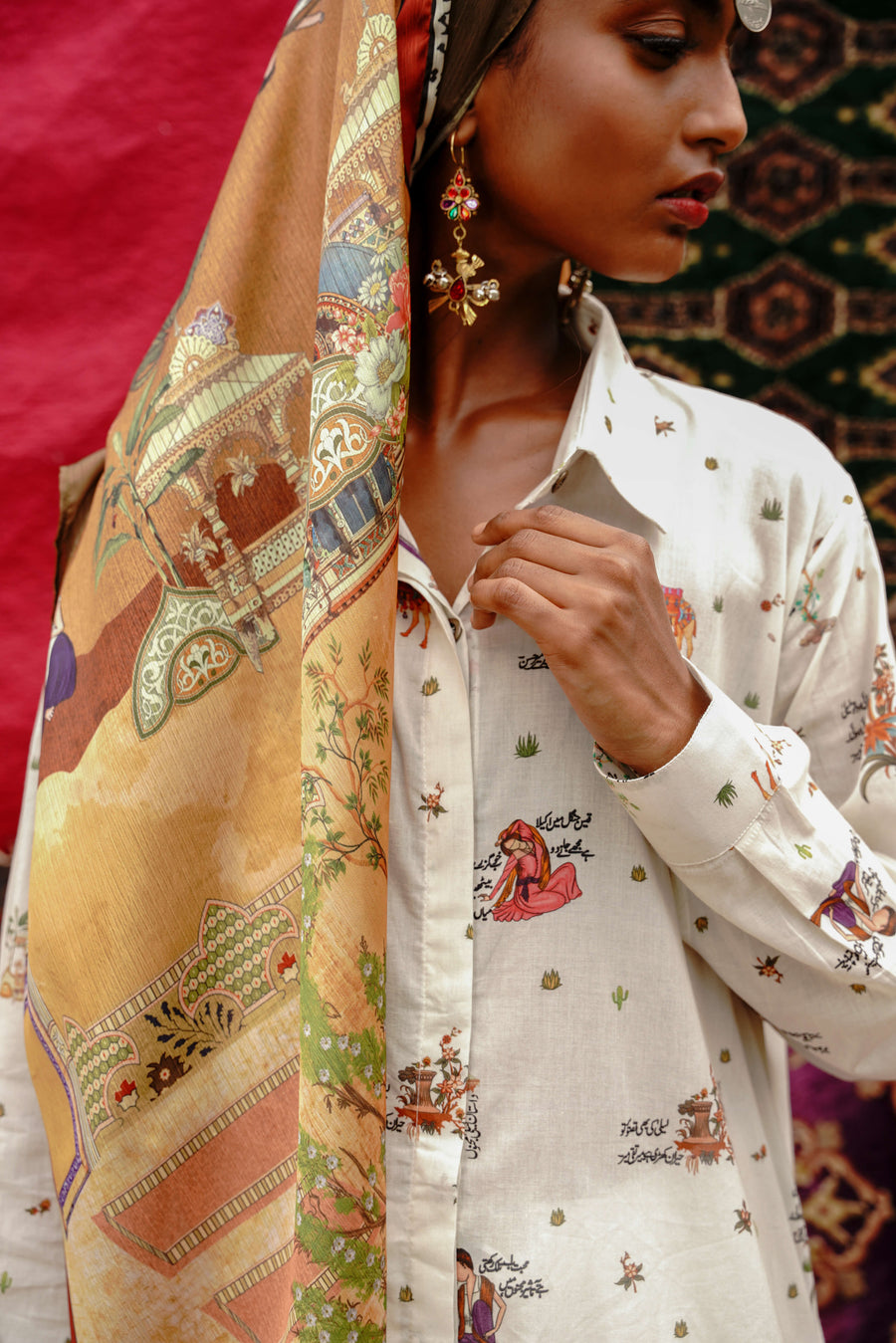 Close-up of woman wearing Kahaani silk scarf with detailed Urdu calligraphy and vibrant traditional designs