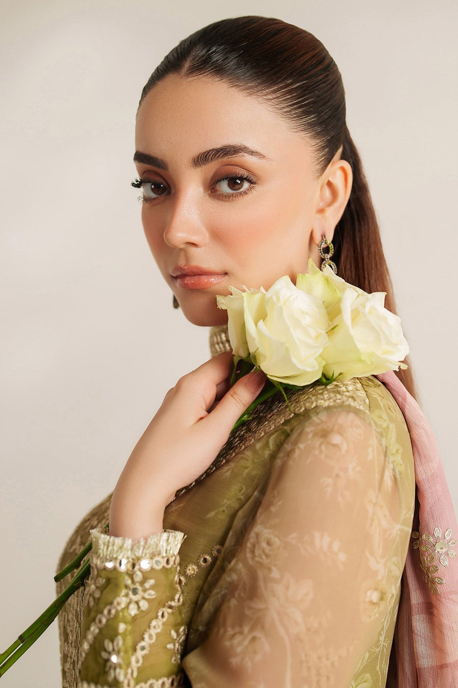 Back view of woman in embroidered olive green Anarkali with pink floral dupatta draped over shoulders and beige heels