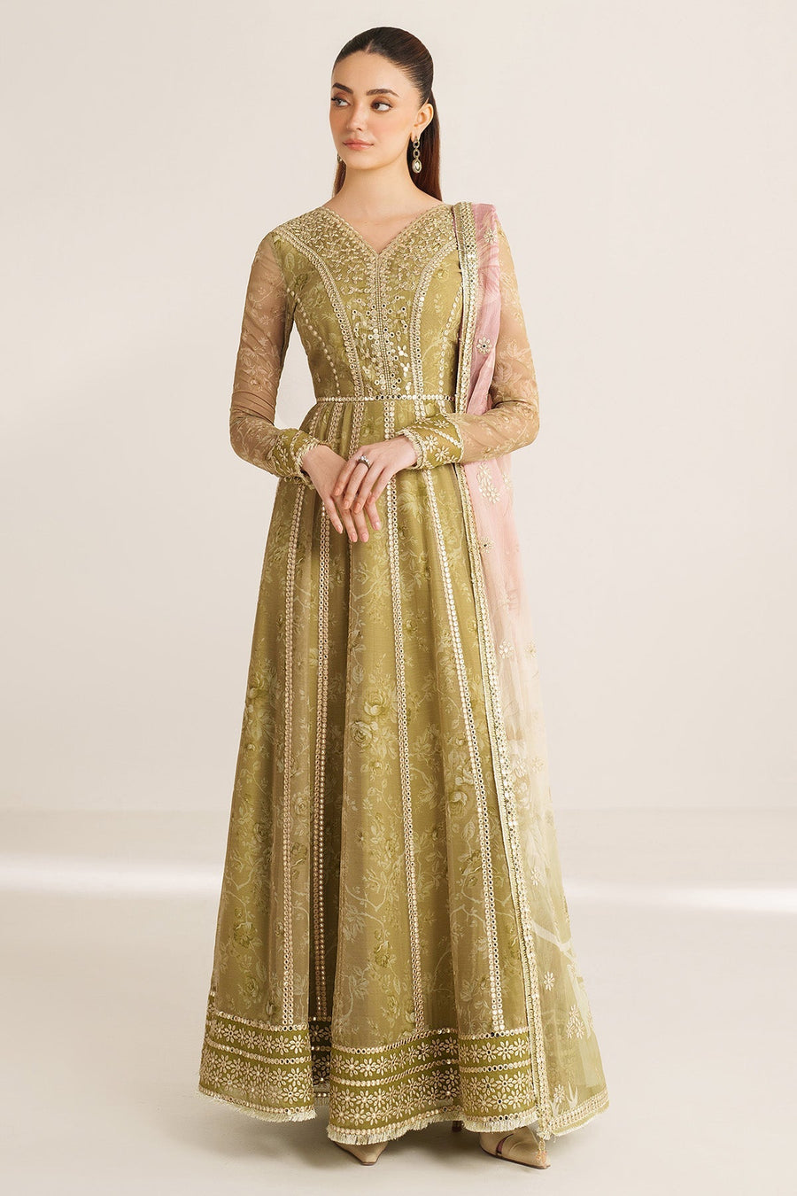 Front view of woman standing with hands crossed in olive green embroidered Anarkali dress and sheer embroidered sleeves