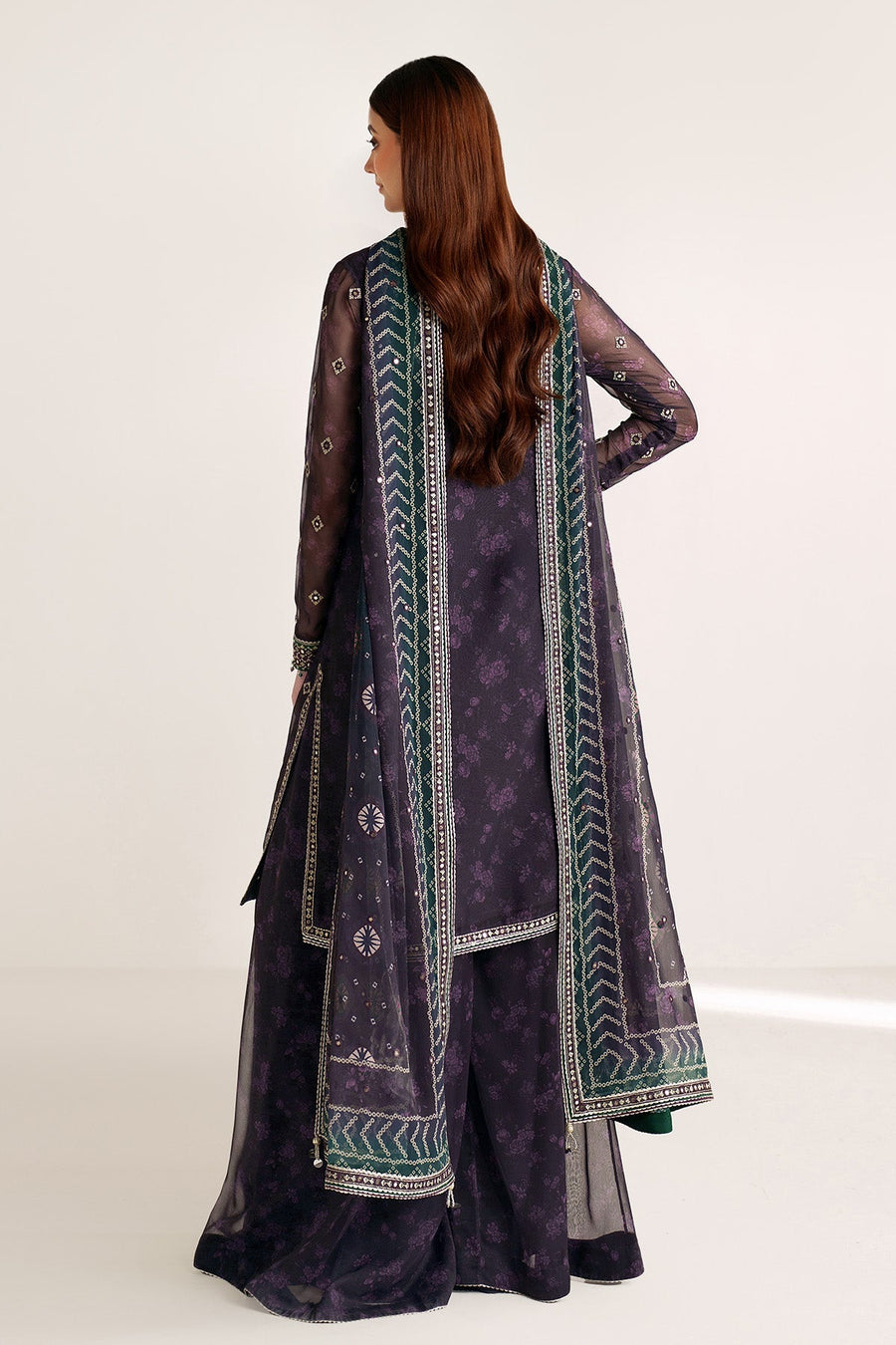 Woman posing with embroidered green and purple dupatta draped over shoulder