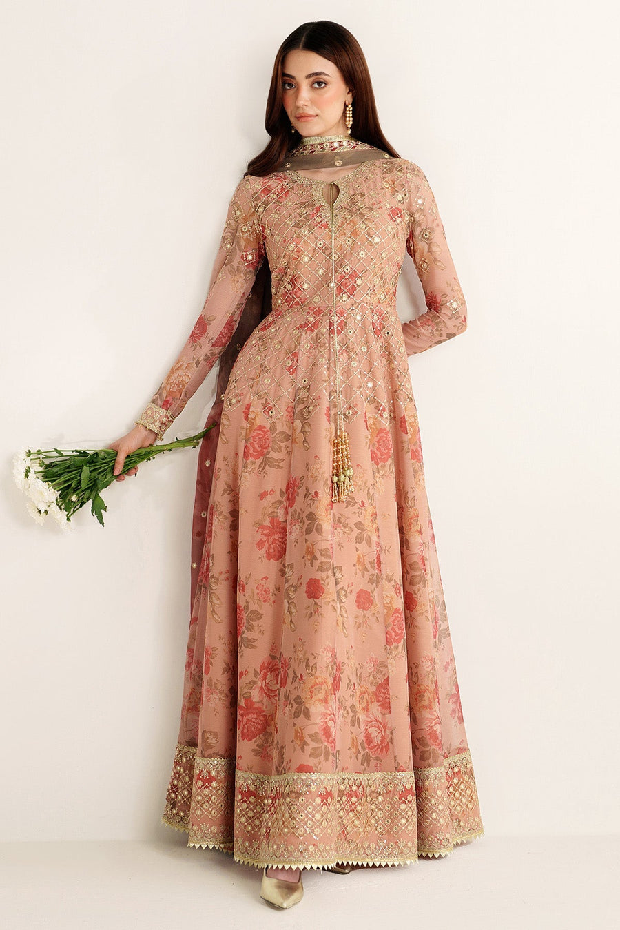 Side profile of woman posing in peach floral embroidered Anarkali suit with long flowing dupatta