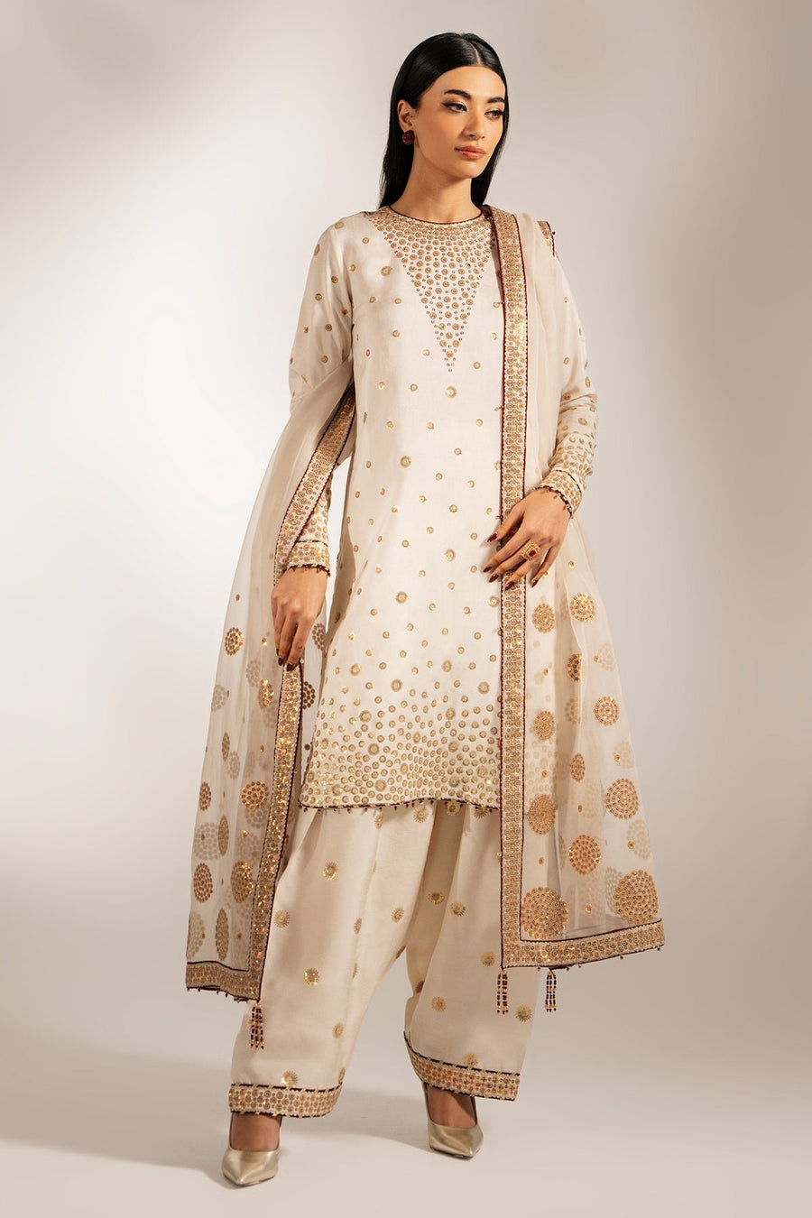 Model posing with embroidered cream dupatta draped over shoulders highlighting the embroidered borders and motifs.