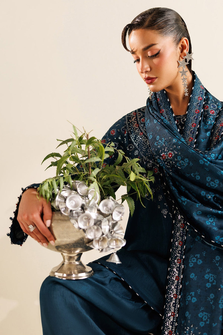 Full back view of woman wearing teal embroidered dupatta with delicate floral print and bell tassels.