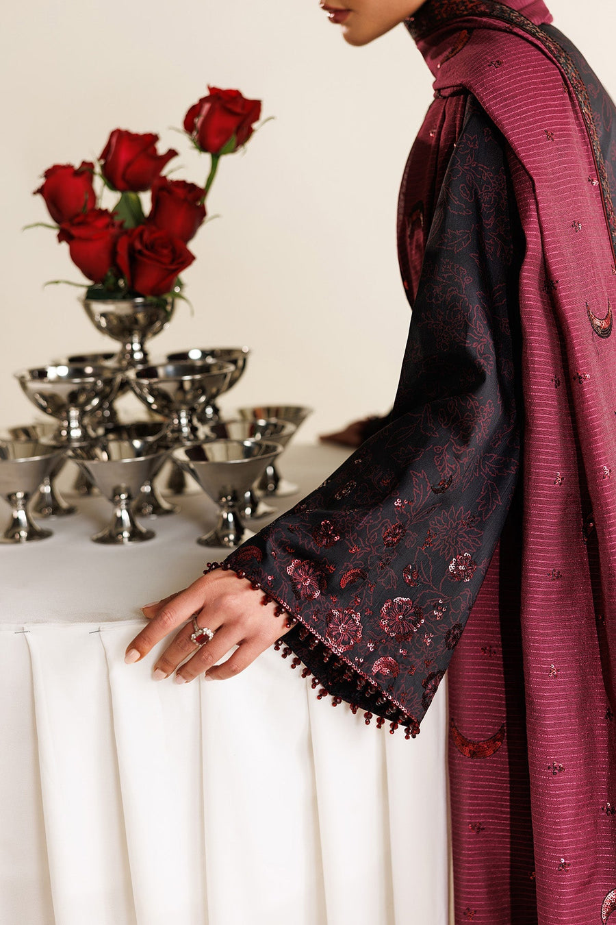 Close-up side profile of model with maroon dupatta styled elegantly over shoulder, highlighting sheen of embroidery and earrings.
