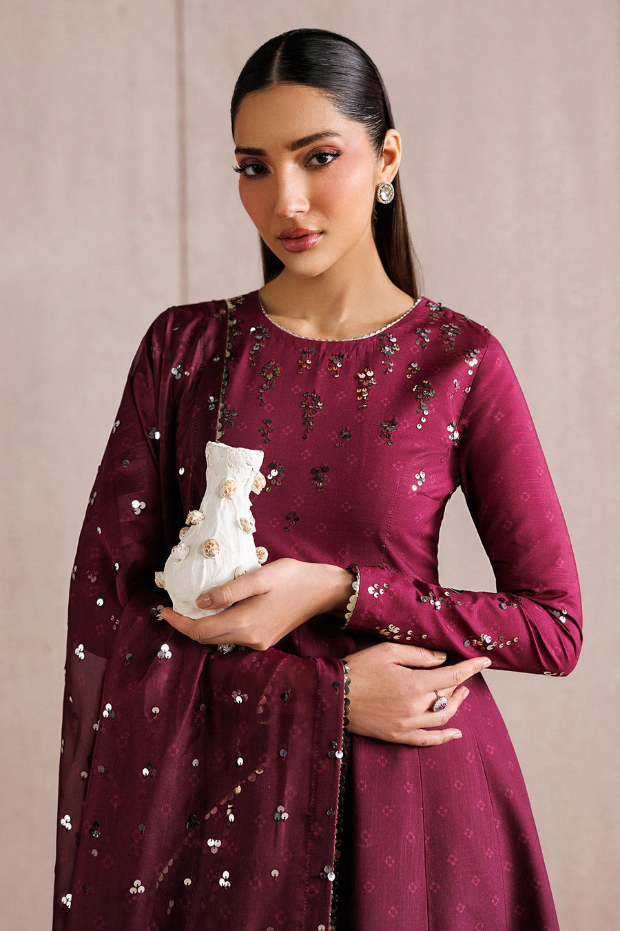Detailed close-up of the embroidery and sequins on the deep magenta raw silk fabric of the Anarkali dress