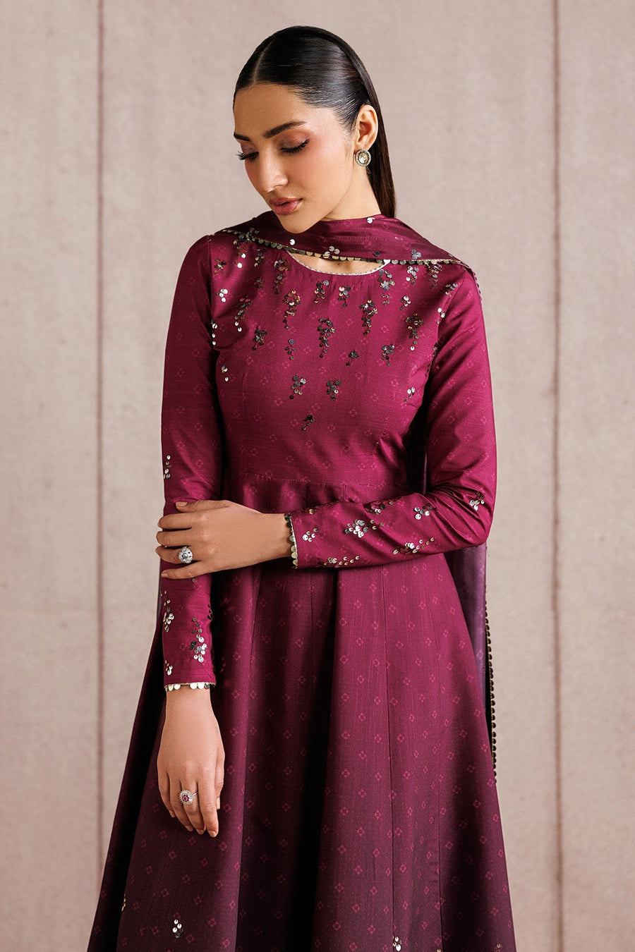 Close-up of woman showing upper body in deep magenta Anarkali suit with sequins and matching dupatta draped on shoulders