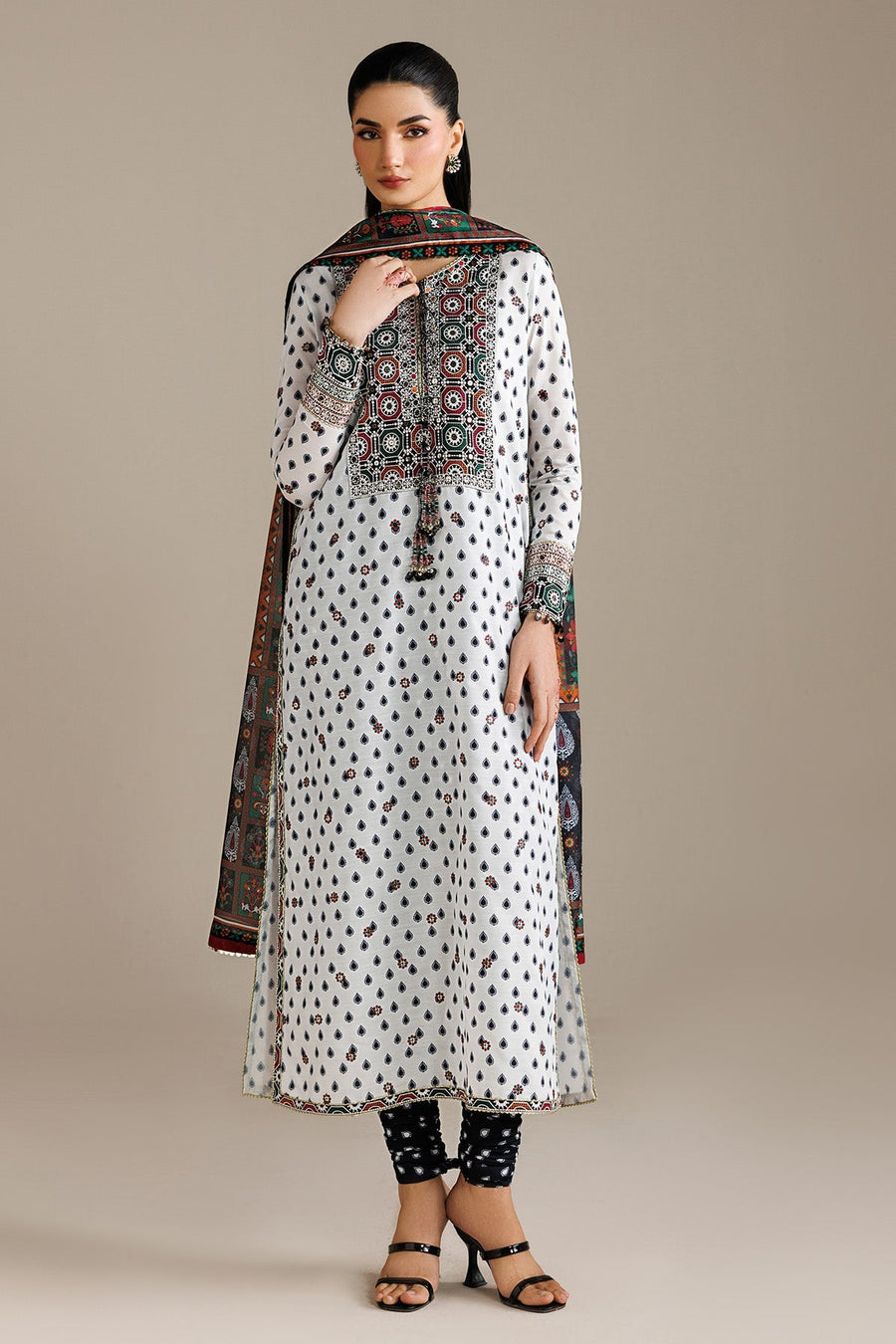 Woman holding printed multi-color dupatta close, showcasing vibrant floral and geometric patterns and intricate hand embroidery on kurta sleeve cuff.