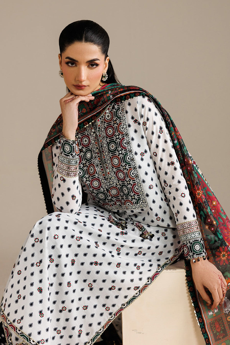Close-up showing the embroidered neckline and cuffs with attached tasseled embellishments, paired with vibrant patterned dupatta.