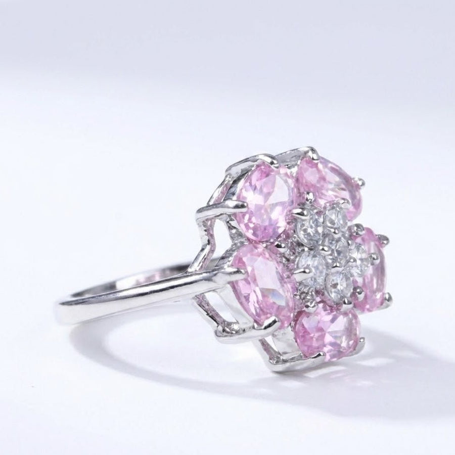 Side perspective highlighting the height and intricate prong setting of pink and clear stones in the flower shaped silver ring.