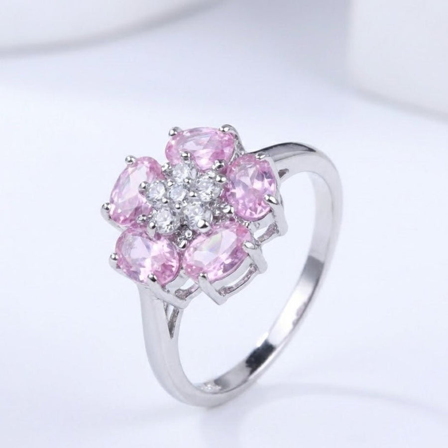 Angled profile of the silver floral ring showing reflective polished band and arrangement of pink and clear stones.