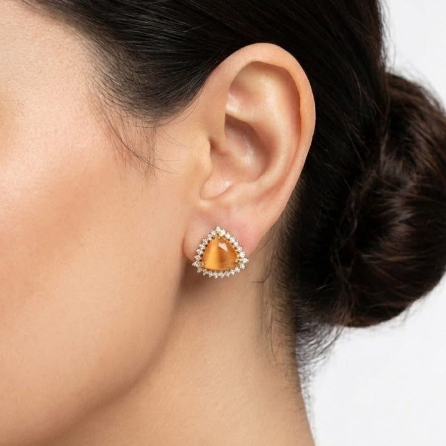 Milky white trillion cut gemstone stud earrings with clear halo stones against white background