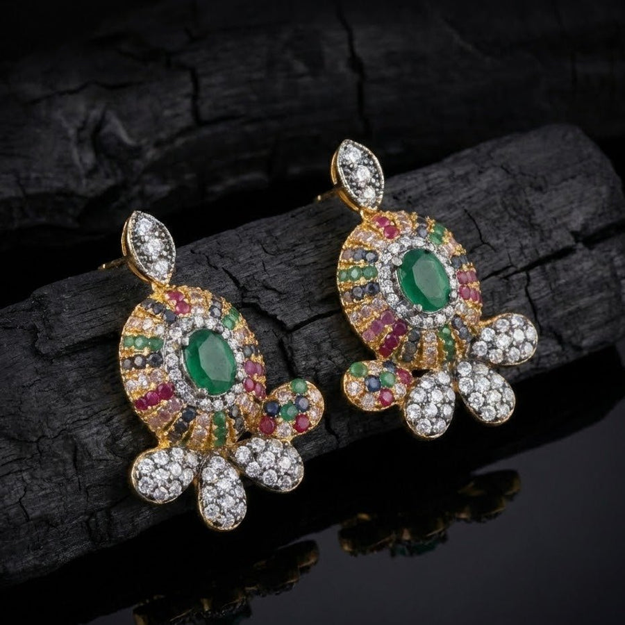 Pink sapphire floral gemstone stud earrings displayed on beige textured surface with yellow flowers