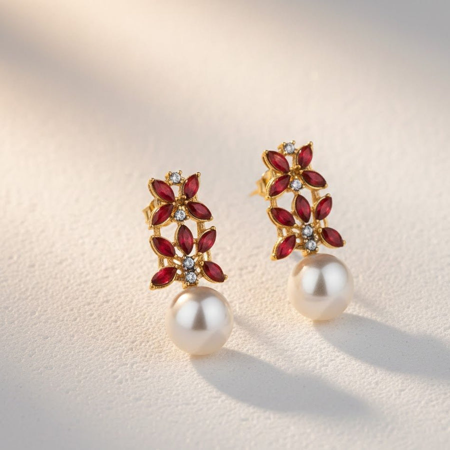 Soft natural light on red stone pearl drop earrings on a beige surface