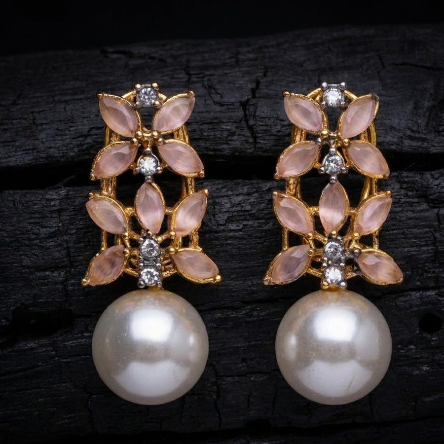 Fashion photography of black stone pearl drop earrings placed on soft beige surface