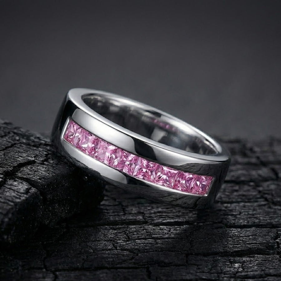Silver band ring with pink stones photographed on textured dark surface highlighting shine