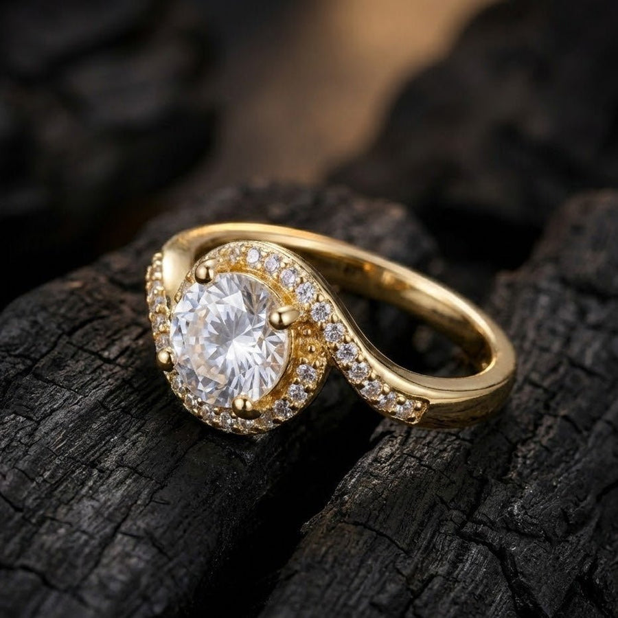 Gold halo diamond ring displayed on textured dark surface highlighting sparkle and design details