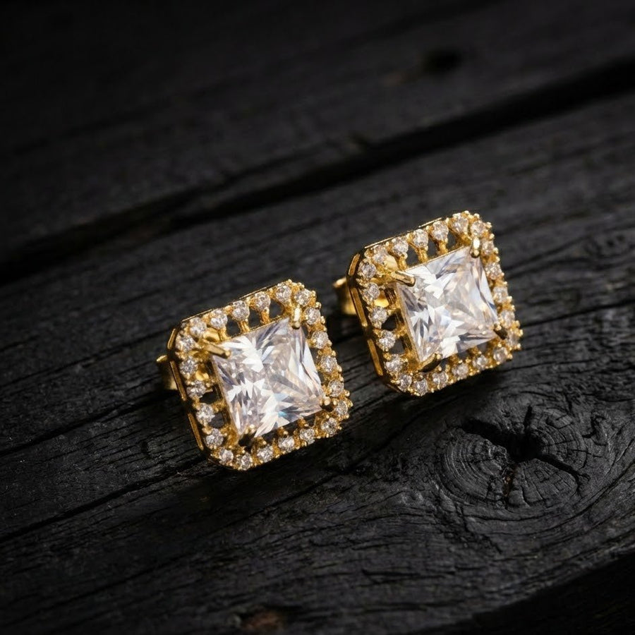 Close-up of clear halo stud earrings on textured dark surface focusing on brilliance and clarity
