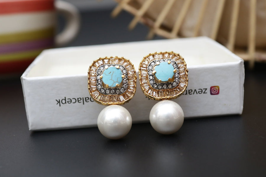 Pair of gold-tone earrings with turquoise central stones surrounded by crystals and large pearl drops