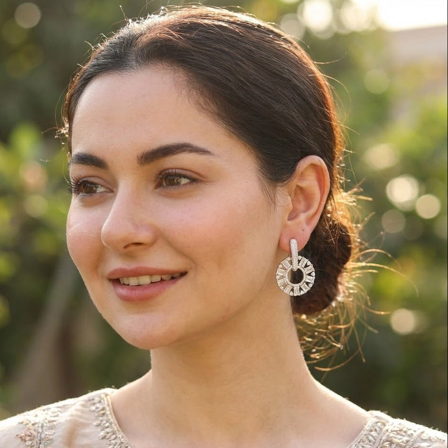 Model wearing silver plated clear stone circle drop earrings with hair tied back