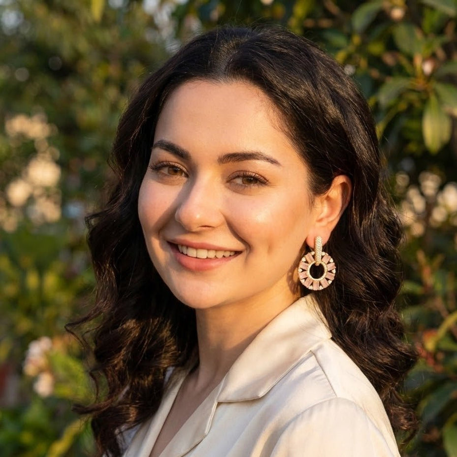 Model wearing gold plated pink stone circle drop earrings outdoors