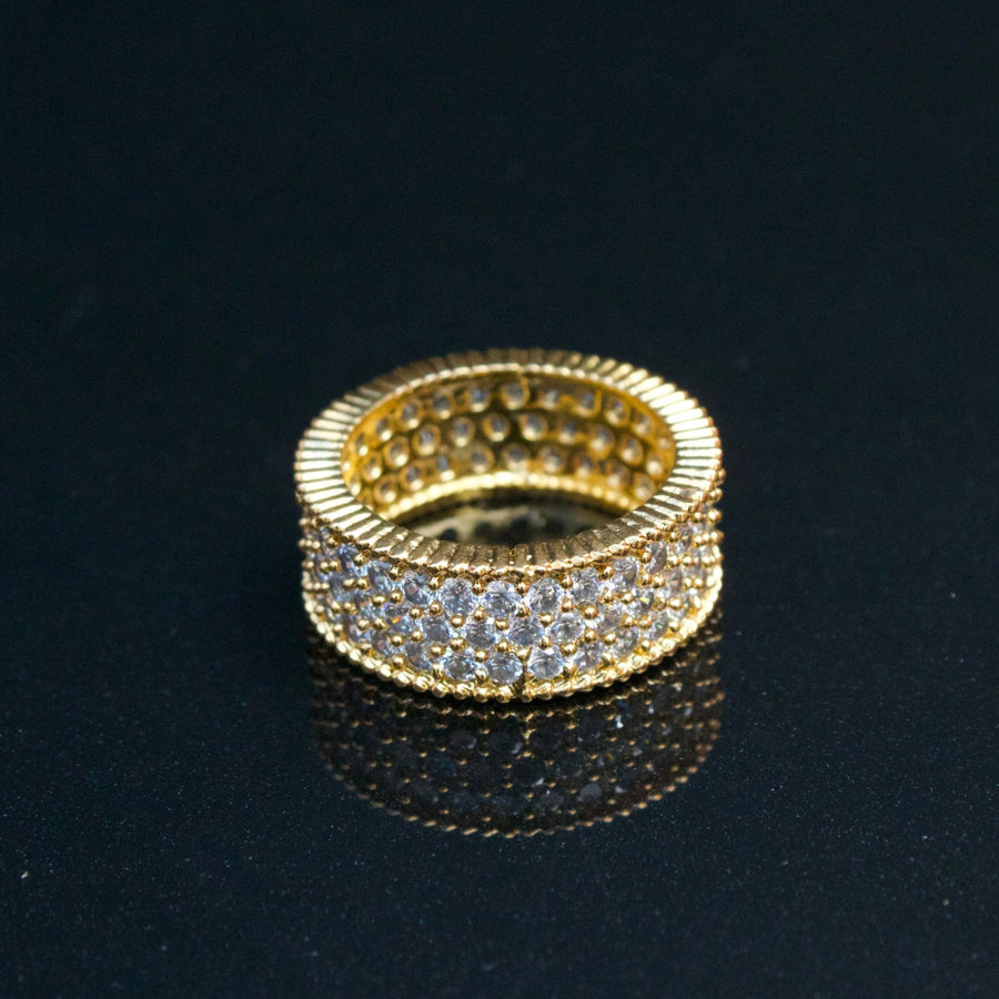 Close-up of two-tone cubic zirconia band ring sitting in a wooden ring box with soft white velvet interior