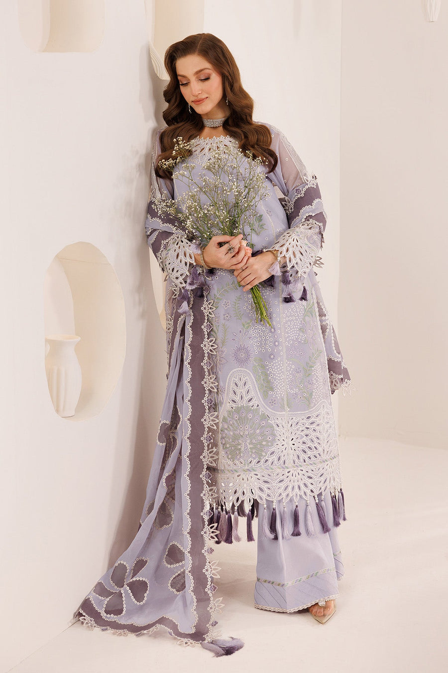 Close-up of neckline and sleeve embroidery with tassel accents on light purple chiffon fabric