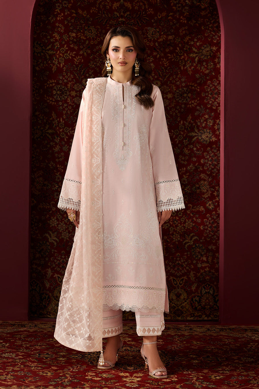 Front view of woman wearing embroidered blush pink lawn suit with chiffon dupatta and matching cotton trousers