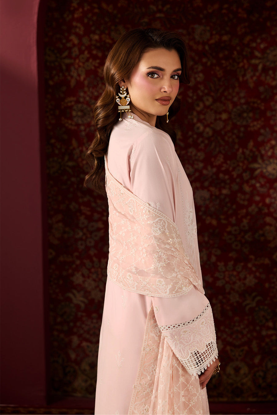 Woman holding and displaying embroidered chiffon dupatta with intricate floral patterns